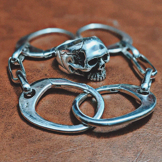 925 silver skull ring placed inside a 925 silver handcuffs bracelt
