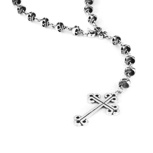 A sterling silver rosary with a crucifix at the center and skull designs on the beads.