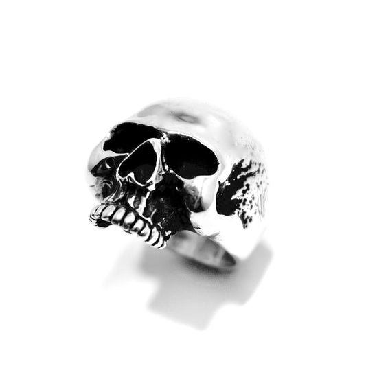 Sterling silver skull ring on a neutral background.