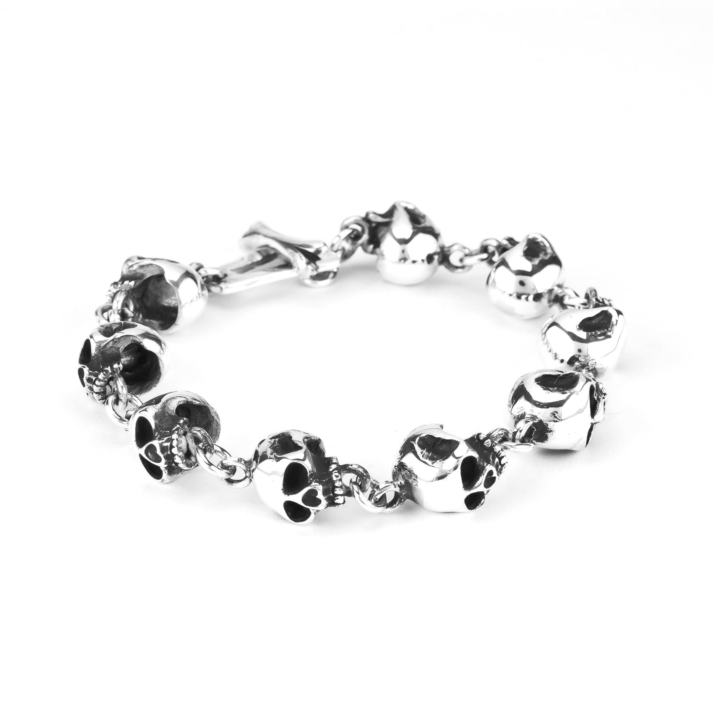A sterling silver bracelet featuring a series of linked skull designs, on a chain.