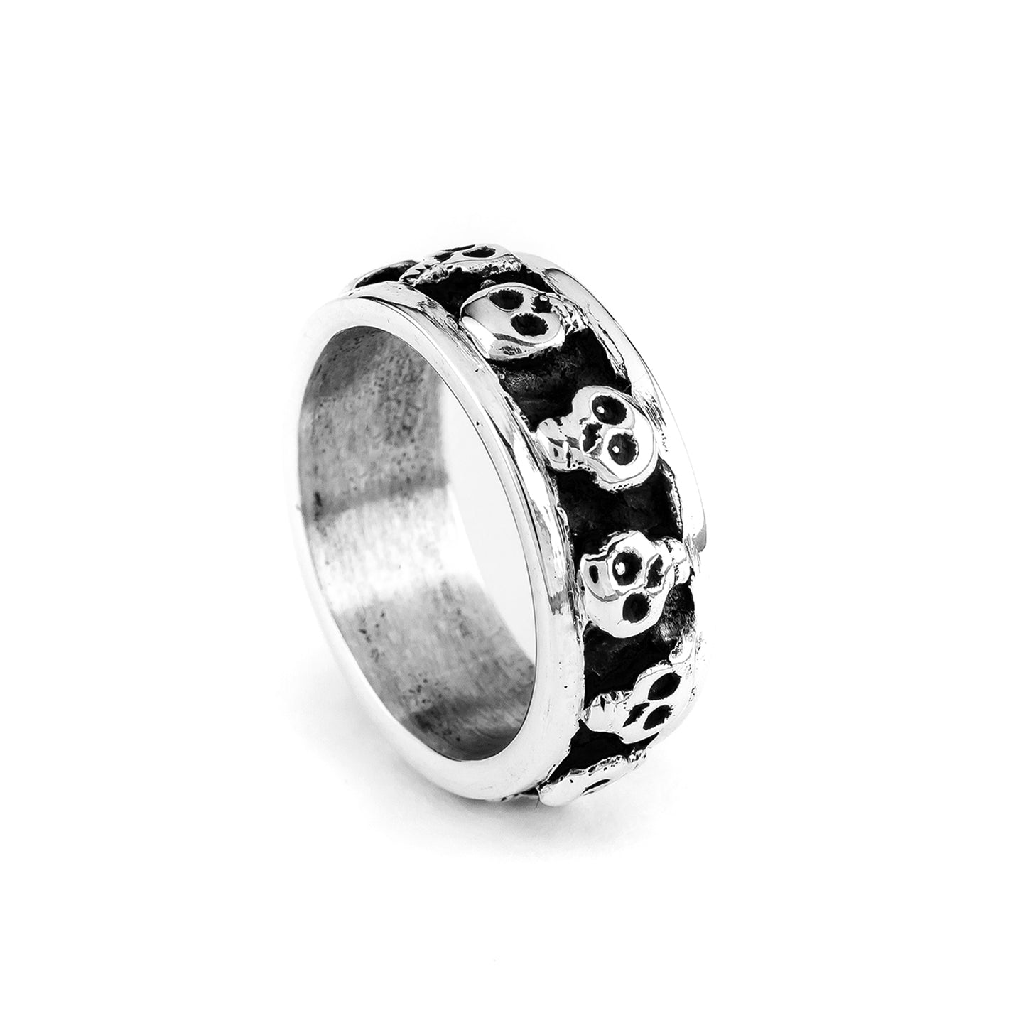 A silver band ring with black skull designs on the top
